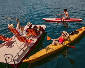 卢塞恩HERMITAGE Lake Lucerne - Beach Club & Lifestyle Hotel的一群人,在水中乘船
