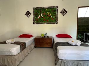 Tirtagangga三泰卡朗阿森别墅旅馆的客房设有两张床和窗户。