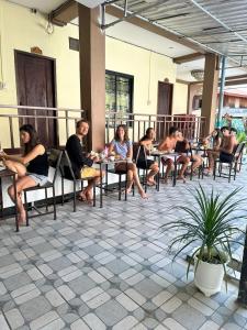 万荣Vang Vieng Global Hostel的坐在庭院桌子上的一群人