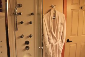 卡斯尔加温德波恩住宿加早餐旅馆的淋浴旁的门口挂着白色的长袍