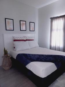 哈博罗内AGM Suites的一间卧室设有一张大床和一个窗户。