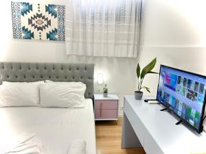 地拉那Tirana Square Hotel的一间卧室配有一张床和一张桌子上的电视