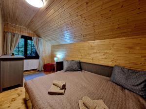 达内什Casa Emmara Sighisoara的木制客房内的一间卧室配有一张大床