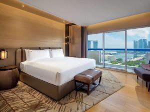 新加坡Swissotel The Stamford Singapore的一间卧室设有一张大床和一个大窗户