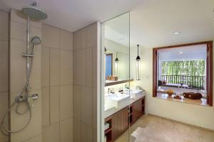 勒吉安The Magani Hotel and Spa的带淋浴、盥洗盆和镜子的浴室