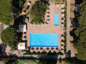 卡帕尔比奥Costa D'Argento - Camping Village Club Capalbio的享有带遮阳伞和一连串停车车的游泳池的顶部景色