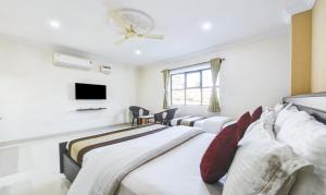 钦奈HOTEL SAlBALA INN - NEAR AIRPORT的一间卧室配有两张床和一台平面电视