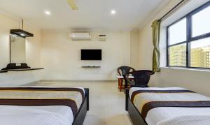 钦奈HOTEL SAlBALA INN - NEAR AIRPORT的客房设有两张床和一台墙上的电视。