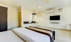 钦奈HOTEL SAlBALA INN - NEAR AIRPORT的卧室配有一张床,墙上配有电视。