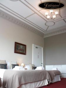 阿德罗森Lauriston Hotel的一间卧室配有一张大床和一个吊灯。