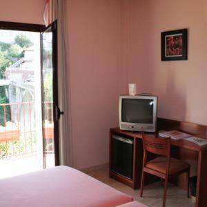 圣基里科-德贝索拉桑特基尔塞德韦索拉酒店的一间卧室配有一张桌子、一台电视和一张床