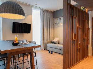 苏黎世Aparthotel Adagio Zurich City Center的客厅配有桌子和沙发