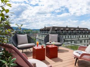 苏黎世Aparthotel Adagio Zurich City Center的一个带桌椅的阳台和一座建筑