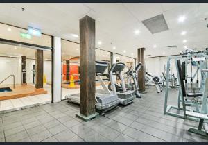 悉尼Goldsbrough Business Boutique的一间健身房,里面配有跑步机和机器