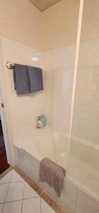 悉尼Goldsbrough Business Boutique的白色的浴室设有浴缸和毛巾。