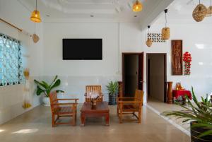 暹粒Zen Angkor Guest House的客厅配有桌椅和电视。