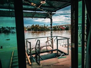 夜功府Watyai GuestHouse的河上的小船,享有桥梁的景色