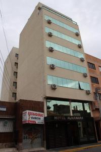 里奥格兰德Hotel Almanara的一座高大的建筑,设有酒店入口