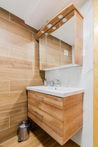 博维茨Apartmaji Mausi的一间带白色水槽和木制橱柜的浴室