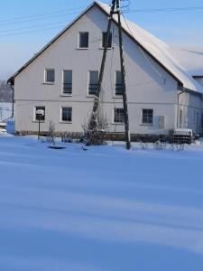 比斯Siedlisko Waliszówka的雪覆盖的田野中间的一个白色大谷仓