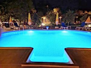 奥林波斯Simurg Evleri Olympos的夜间游泳池,配有椅子和遮阳伞