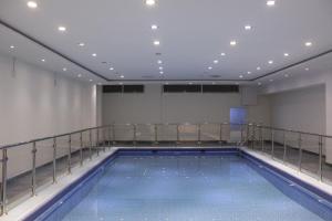 利雅德阿拉法迪拜塔奥哈亚套房酒店的带阳台的大楼内的大型游泳池