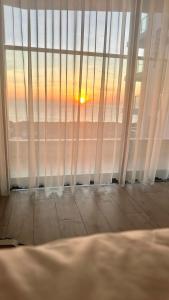 绥和市Apec Mandala Phú Yên View Biển的客房设有可欣赏日落美景的窗户。
