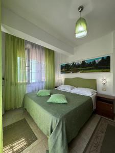斯库台卡杜库酒店的一间卧室配有一张带绿色窗帘的大床