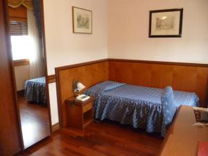波代诺内米内尔瓦酒店的一间卧室配有蓝色的床和镜子