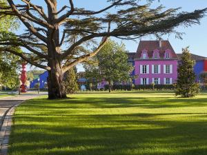 Saint-Sylvestre-sur-Lot斯特西亚酒店的草上一棵树的粉红色房子