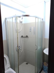 马尼拉GM Staycation的浴室设有玻璃淋浴间和卫生间