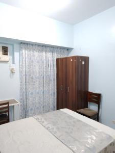 马尼拉GM Staycation的一间卧室配有一张床、一个橱柜和一张书桌