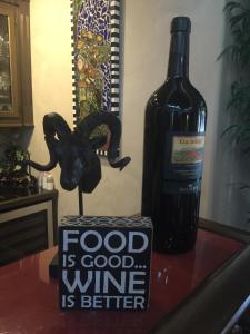 YoungsvilleLouisiana Cajun Mansion的一瓶葡萄酒和一瓶葡萄酒旁边的桌子上的标志