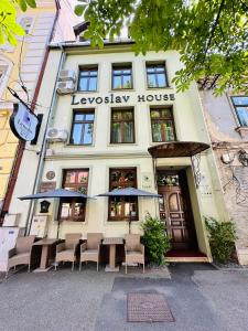 锡比乌Villa & Restaurant Levoslav House的前面设有桌椅的建筑