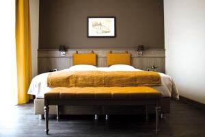 富伦庞思岱富伦酒店的一间卧室配有一张大床和两个橙色枕头