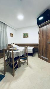 苏博蒂察Kollar D Guest House - Prenoćište ROOMS的配有桌椅和床的房间