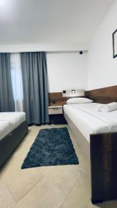 苏博蒂察Kollar D Guest House - Prenoćište ROOMS的酒店客房带两张床和蓝色地毯