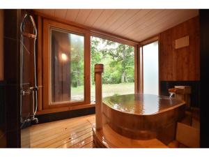 阿寒湖畔阿寒河拉维斯塔温泉酒店的窗户客房内的大型木制浴缸