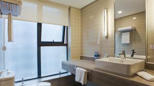 西安西安高新智选假日酒店的一间带水槽、浴缸和镜子的浴室