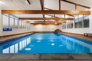 墨尔本希拉玛斯机场旅舍的拥有蓝色海水和木质天花板的室内游泳池