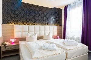 斯图加特巴伐利亚慕尼黑高级酒店的配有白色枕头的酒店客房内的两张床