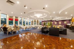 墨尔本希拉玛斯机场旅舍的用餐室设有桌椅和窗户。