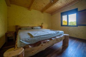 波德戈里察Rustic Cottage Montenegro Bridje的一间带木床的卧室,位于带窗户的房间内