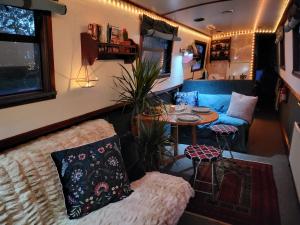 伦敦Comfy Canal Boat in Little Venice by Paddington for Family & Friends的带沙发和桌子的客厅