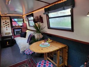 伦敦Comfy Canal Boat in Little Venice by Paddington for Family & Friends的客厅配有桌子和沙发