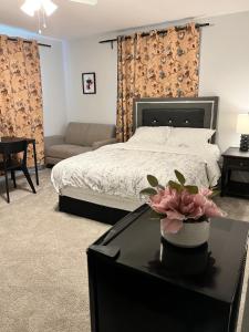 萨克拉门托Cozy Suite with On Site Parking Close to Downtown and UC Davis Medical Center的一间卧室配有一张床和一张桌子,上面有花