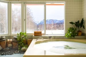 小谷村Canopy Lodge - Boutique Lodge at Hakuba Cortina的带浴缸的浴室,带窗户