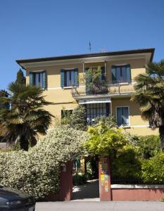 马格拉Atika & Atif - Antica Villa Graziella Venice的一座大型黄色建筑,设有阳台和树木