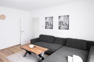 林茨Top City Apartment in Linz mit Netflix的客厅配有沙发和桌子