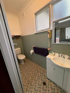 库马ALPINE COUNTRY MOTEL and METRO ROADHOUSE COOMA的一间带水槽和卫生间的浴室